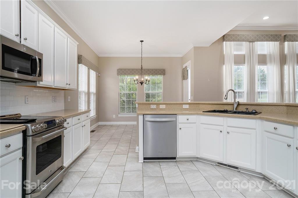 1416 Shade Tree Court Matthews, NC 28104 - Photo 4 of 22 a kitchen with a sink stove and microwave