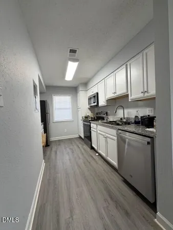 a kitchen with granite countertop white cabinets and white appliances