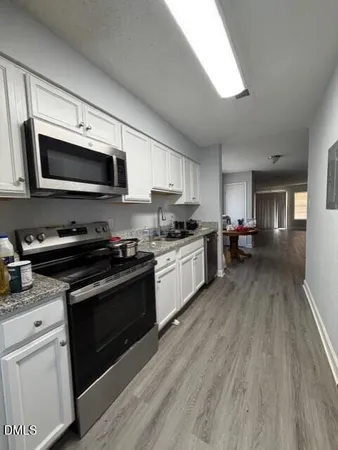 a kitchen with stainless steel appliances kitchen island granite countertop a stove cabinets and microwave