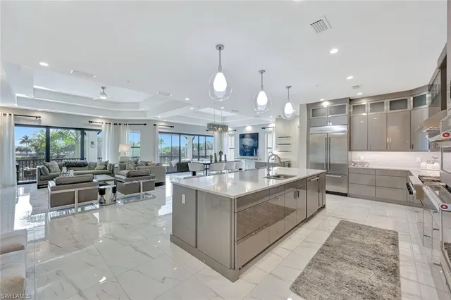a large kitchen with kitchen island a sink a stove a dining table and chairs