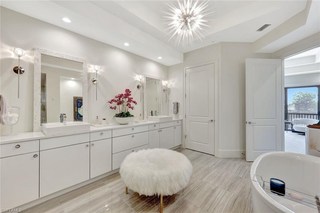 16350 Corsica Way, Unit 202 Naples, FL 34110 - Photo 16 of 39 a spacious en suite bathroom with a toilet a sink and mirror