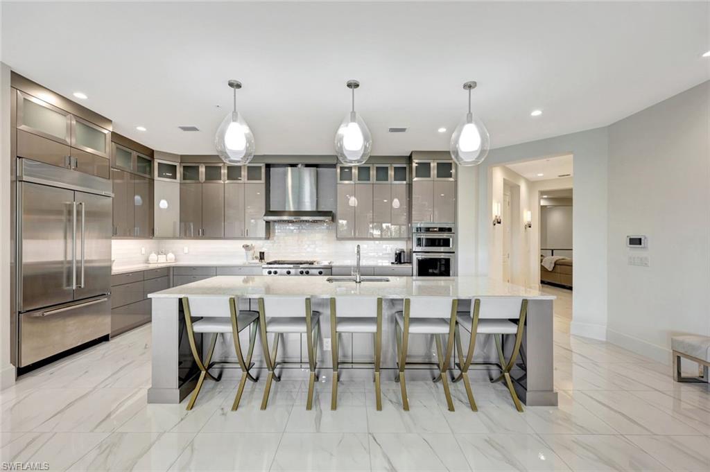 16350 Corsica Way, Unit 202 Naples, FL 34110 - Photo 8 of 39 a large kitchen with a table and chairs