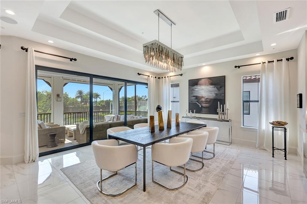 16350 Corsica Way, Unit 202 Naples, FL 34110 - Photo 10 of 39 a dining room with furniture a chandelier and window