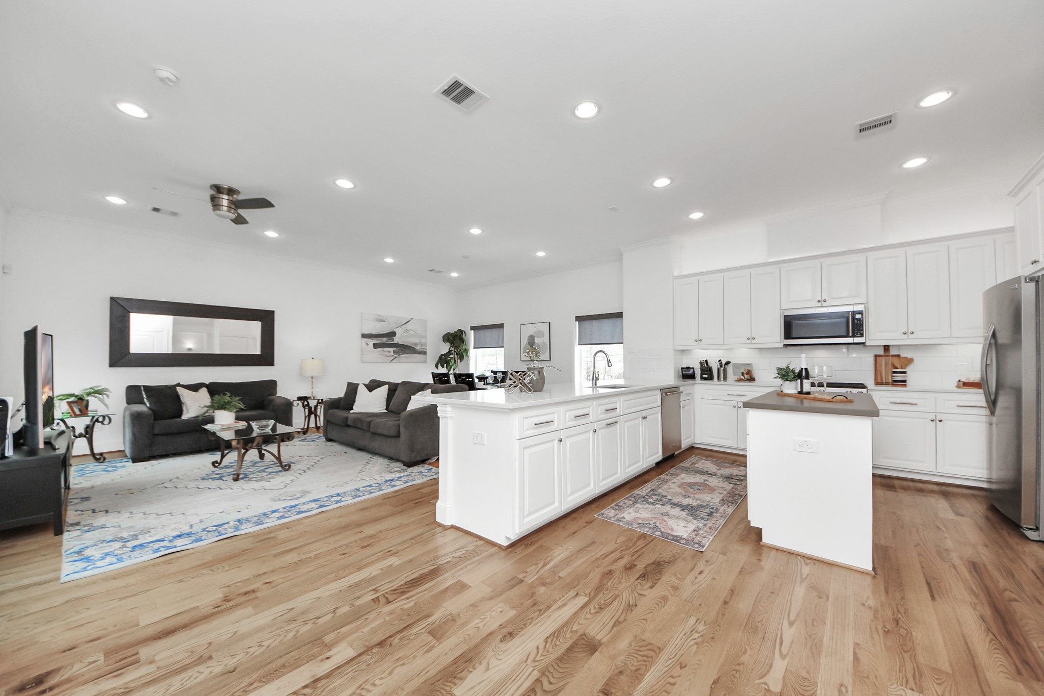 1628 West 24th Street Houston, TX 77008 - Photo 11 of 40 The expansive second-floor open concept living area features a sleek kitchen, dining, and living space, complemented by a pantry, versatile storage closet that is on all 4 floors creating an elevator capable home, and a discreet half bath tucked behind the kitchen.