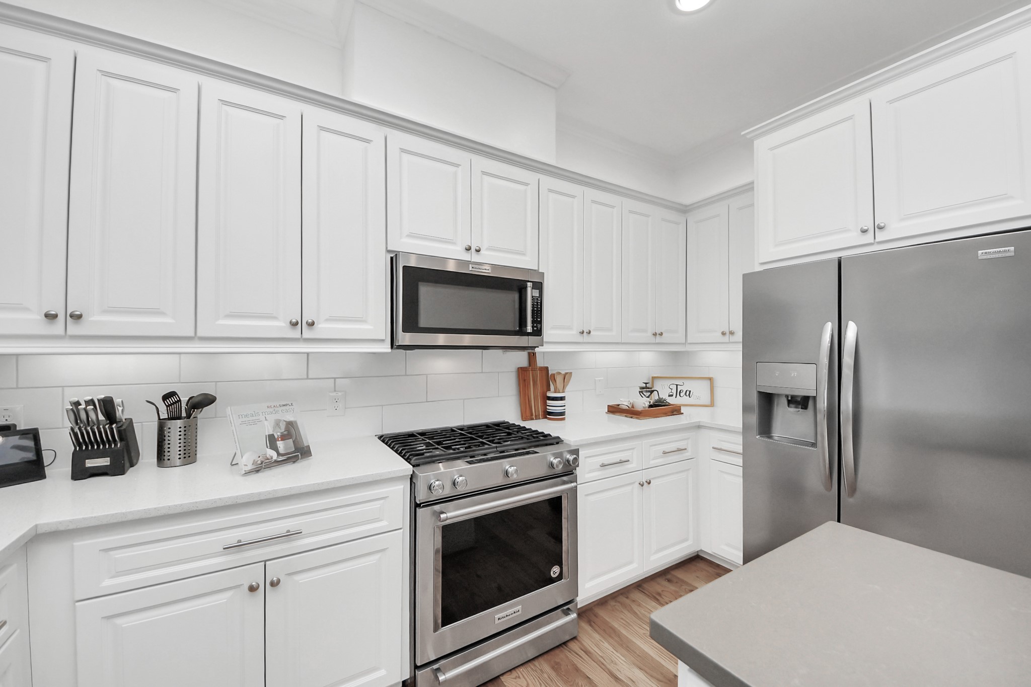1628 West 24th Street Houston, TX 77008 - Photo 12 of 40 Crisp white kitchen with stainless steel appliances, perfect for crafting your gourmet meals in style.