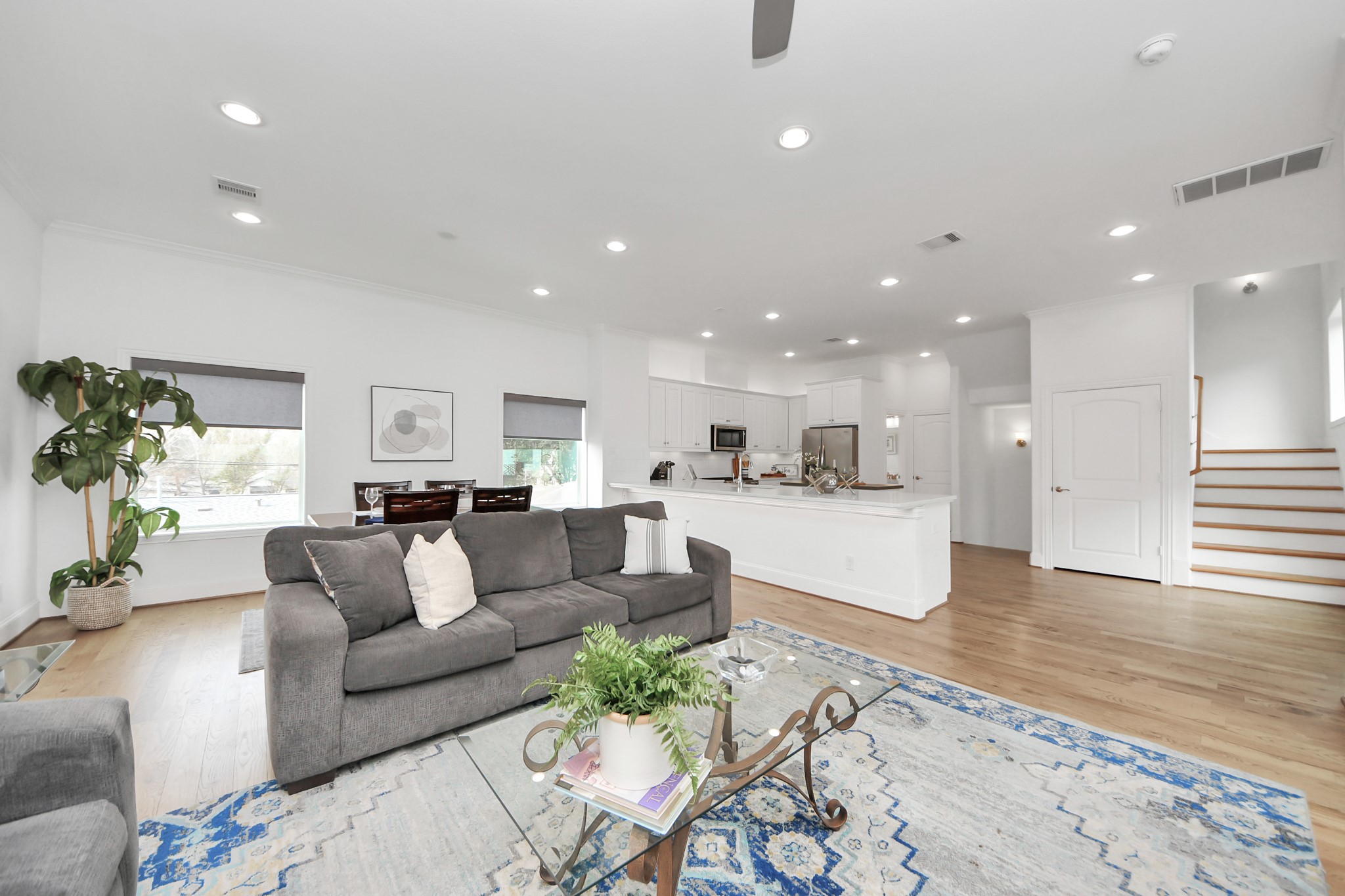1628 West 24th Street Houston, TX 77008 - Photo 18 of 40 This open-plan living space features a bright and airy design with hardwood floors, a modern kitchen with stainless steel appliances, and a cozy seating area. Natural light floods the room through large windows. Perfect for entertaining and family living.