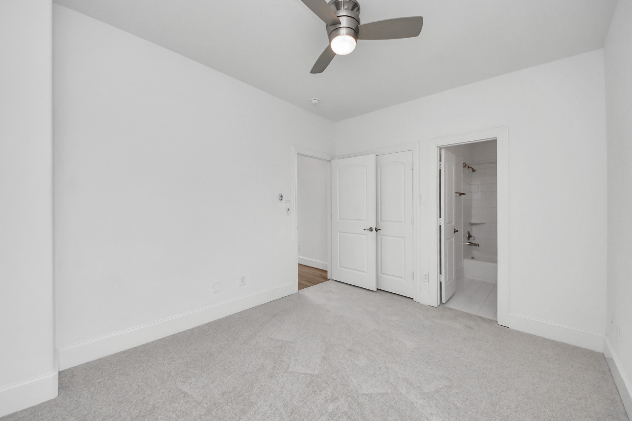 1628 West 24th Street Houston, TX 77008 - Photo 21 of 40 New plush carpet (installed in all bedrooms in December 2025), a spacious walk-in closet, and a convenient ensuite bathroom in this third- floor secondary bedroom.