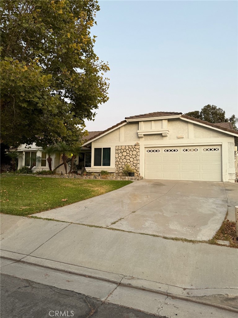 a view of white house with a yard and large tree