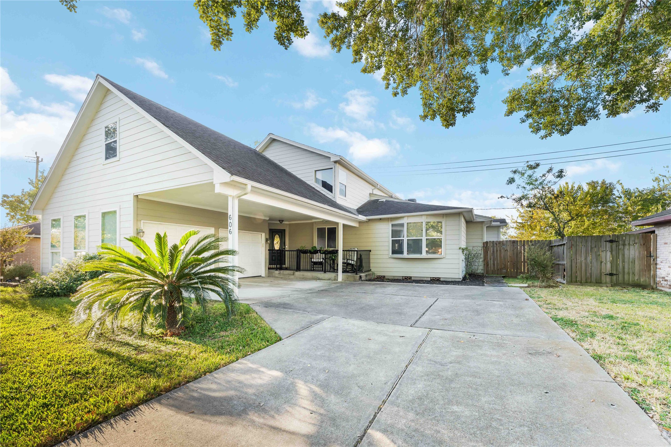 This charming two-story home features a modern exterior with a spacious driveway and covered parking. A well-maintained lawn and mature trees enhance its curb appeal, offering a welcoming and serene atmosphere.