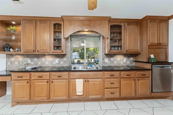 a kitchen with granite countertop white cabinets stainless steel appliances a sink and dishwasher