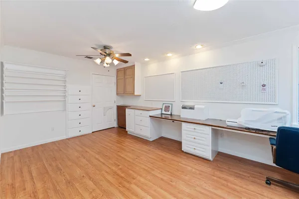 a large white kitchen with a sink dishwasher a stove and a refrigerator with wooden floor