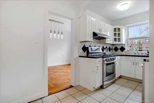 a kitchen with white cabinets and appliances