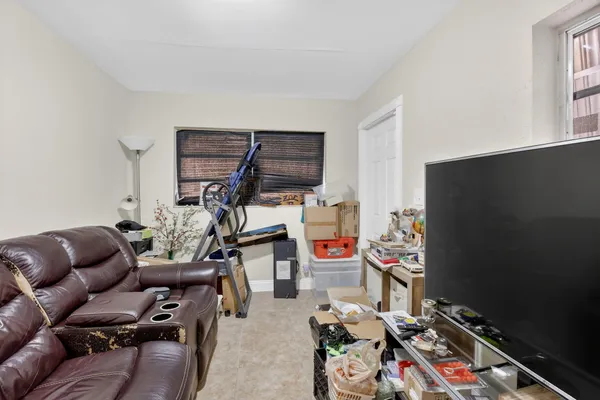 a living room with furniture a flat screen tv and gym equipment