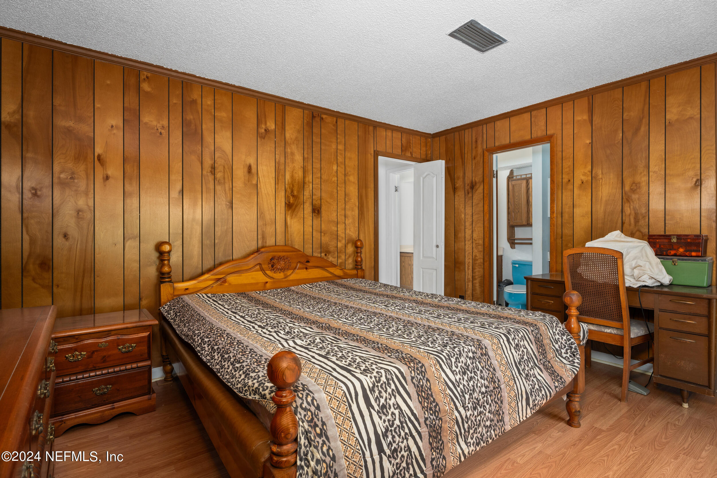 8080 Ibach Road Jacksonville, FL 32216 - Photo 24 of 34 a bedroom with a bed and a chandelier