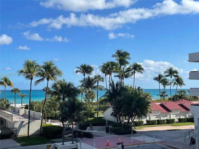 a palm tree sitting in front of a house with a yard
