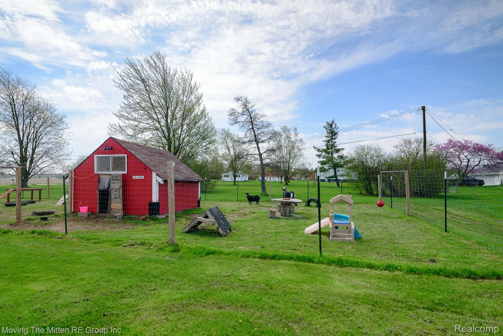 9260 Pitman Road Ypsilanti, MI 48197 - Photo 33 of 45 View of grassy yard with an outdoor structure, a garage, and exterior structure
