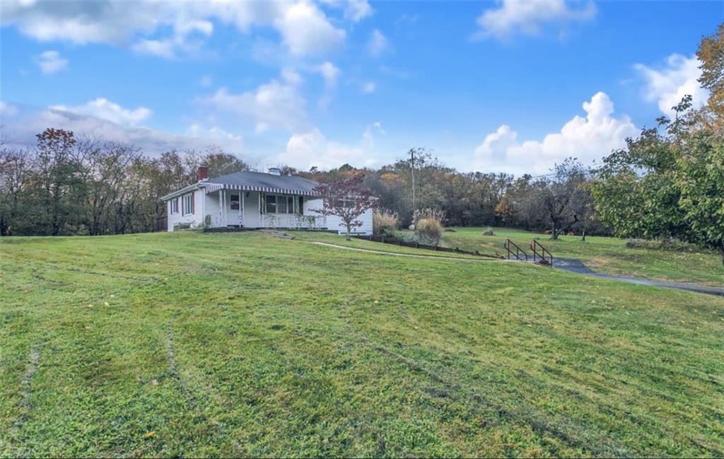 a view of a big yard with a house in the background