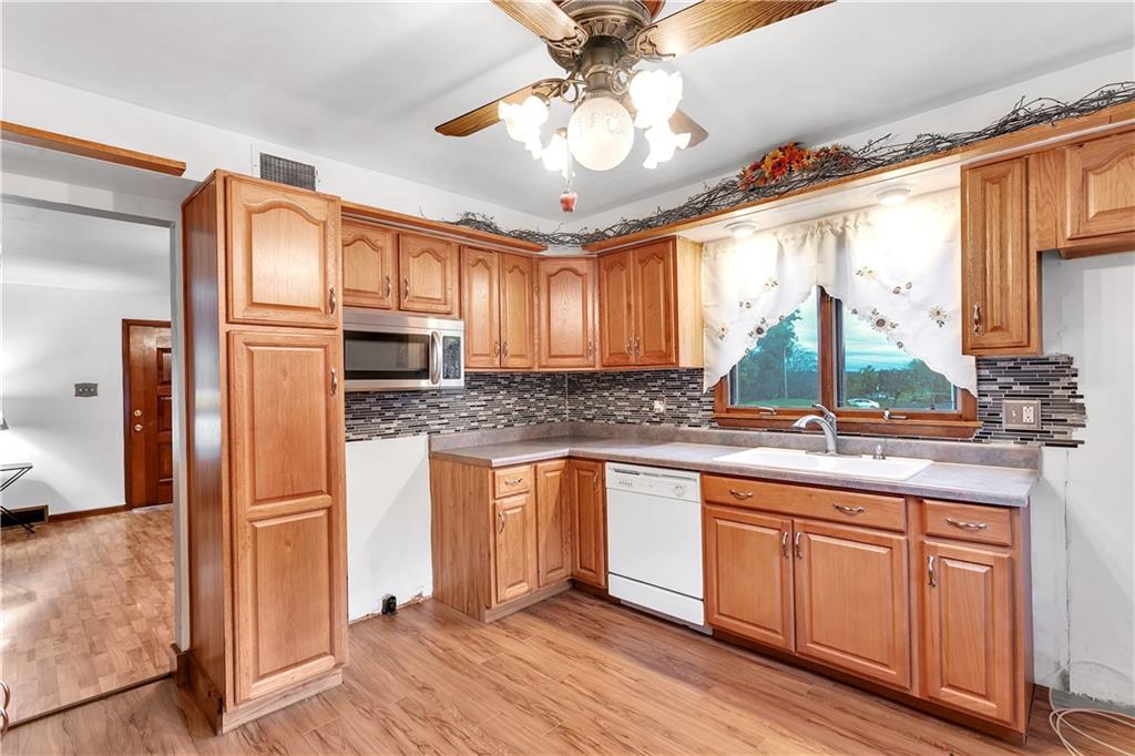 129 Shaffer Road Apollo, PA 15613 - Photo 6 of 25 a kitchen with stainless steel appliances granite countertop a refrigerator a sink dishwasher a stove and white countertops with wooden floor