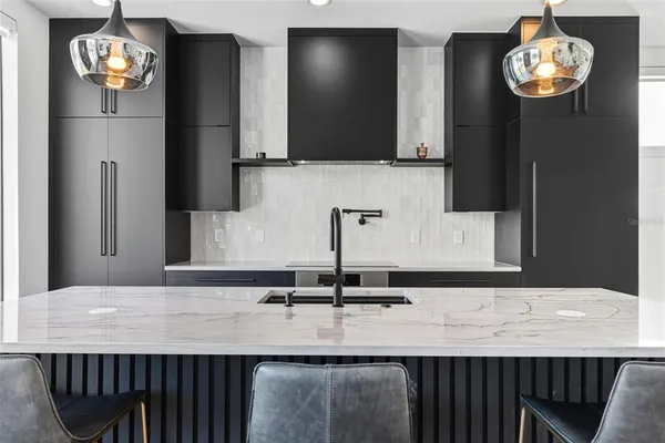 a bathroom with a sink a large mirror and cabinets