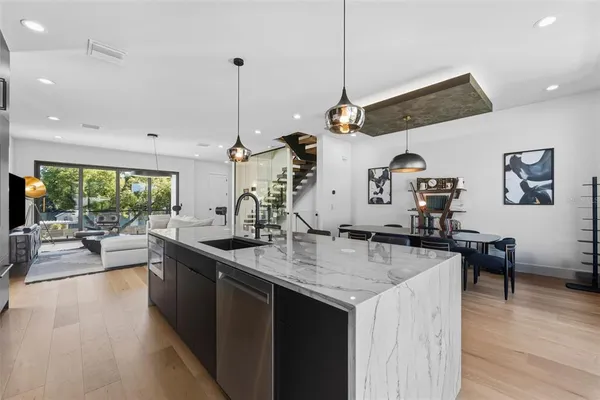 a kitchen with stainless steel appliances granite countertop a sink a stove and a wooden floors