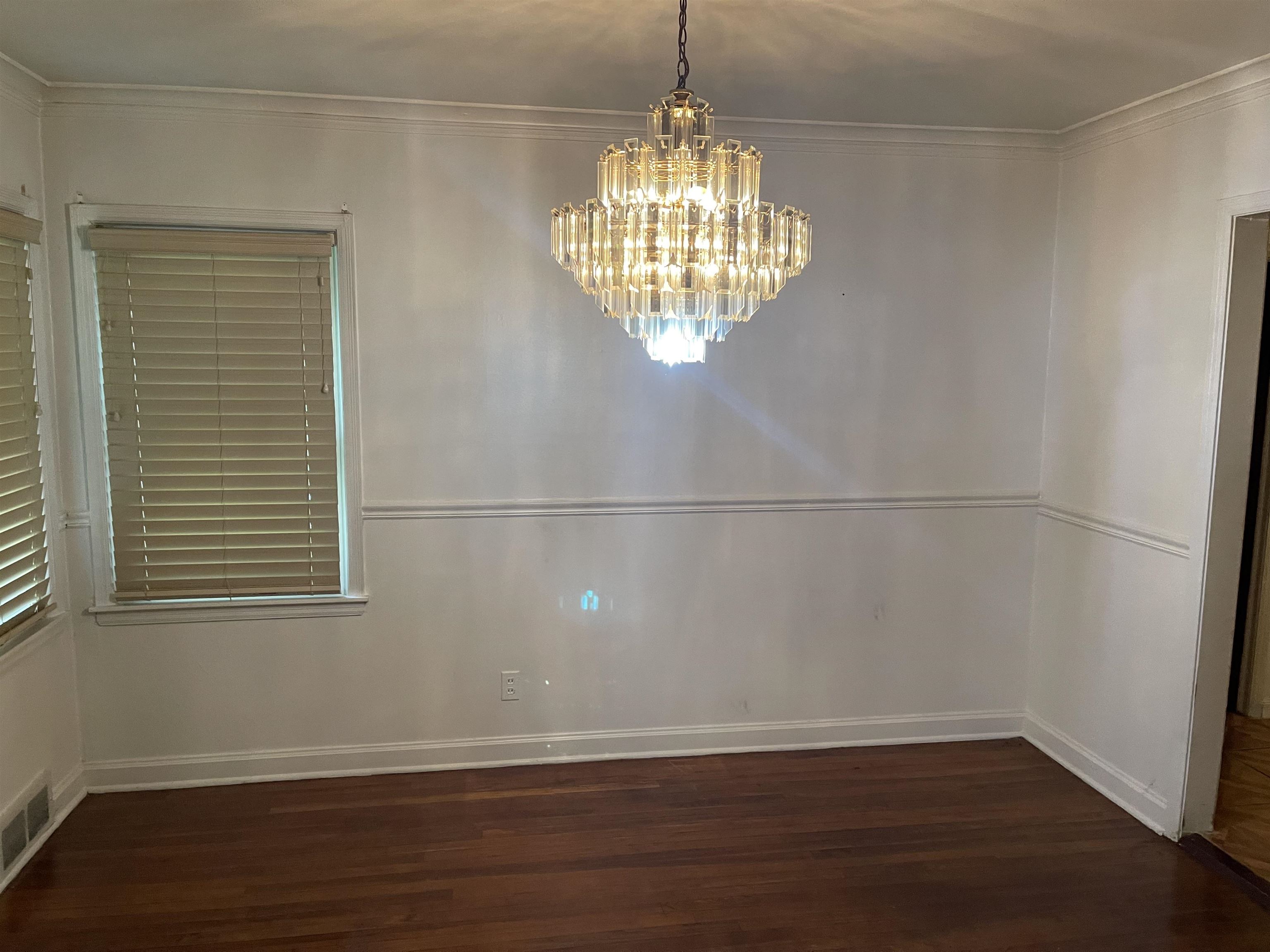 895 Enfield Road Memphis, TN 38116 - Photo 3 of 9 a view of an empty room with wooden floor and a window