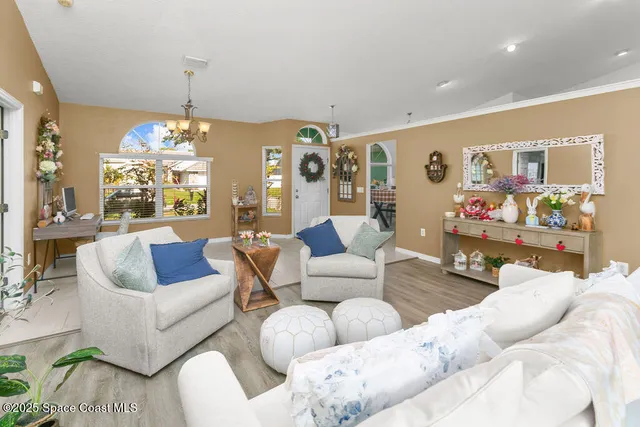 a living room with furniture and a chandelier
