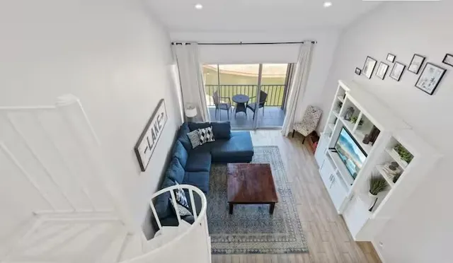 a living room with furniture and a floor to ceiling window