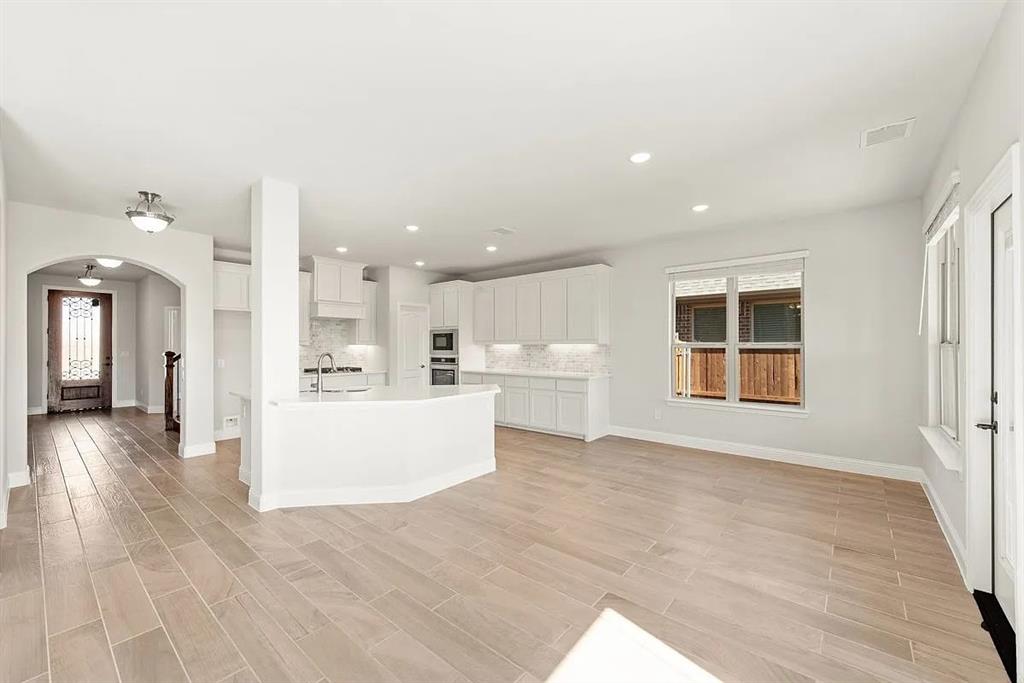 1232 Starlight Avenue Aubrey, TX 76227 - Photo 11 of 22 a view of a living room and kitchen with furniture floor to ceiling window
