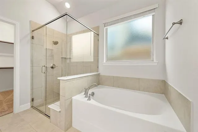 a white bath tub sitting next to a shower