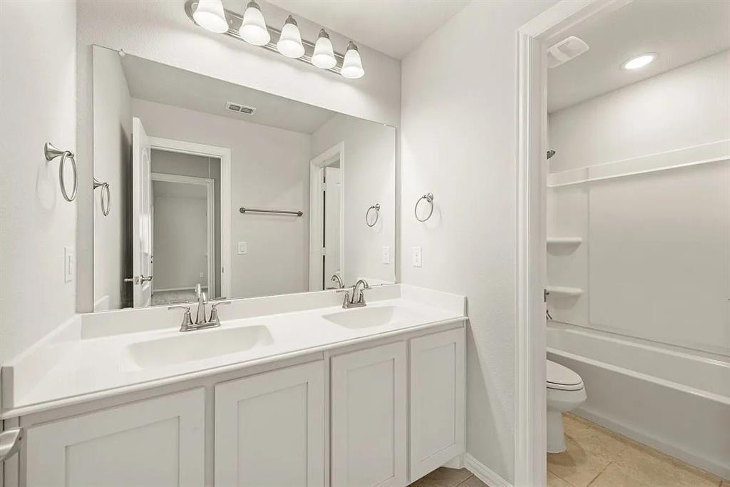 1232 Starlight Avenue Aubrey, TX 76227 - Photo 16 of 22 a bathroom with a double vanity sink mirror and a bathtub