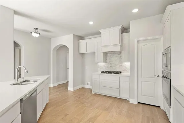 a kitchen with white cabinets and stainless steel appliances
