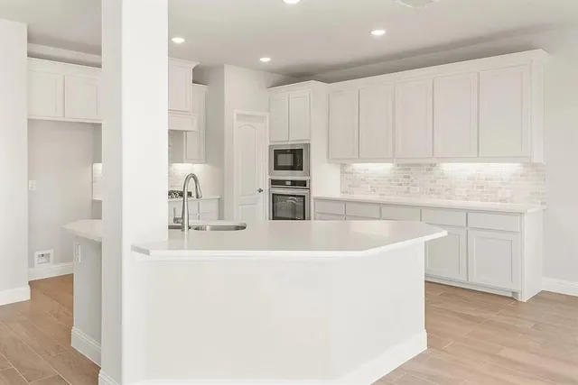 a kitchen with kitchen island a sink stainless steel appliances and cabinets