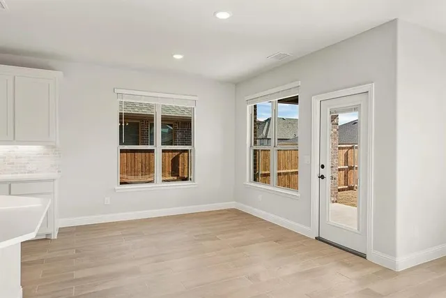 an empty room with a window and wooden floor