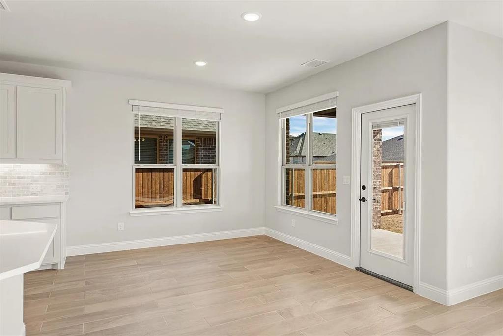 1232 Starlight Avenue Aubrey, TX 76227 - Photo 10 of 22 an empty room with a window and wooden floor