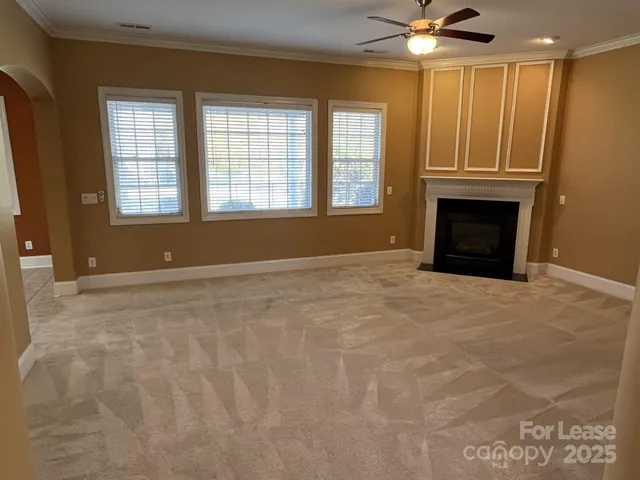 a view of an empty room with a fireplace and a window