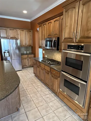 a kitchen with stainless steel appliances granite countertop a stove a sink and a microwave