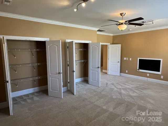 a view of an empty room with a ceiling fan