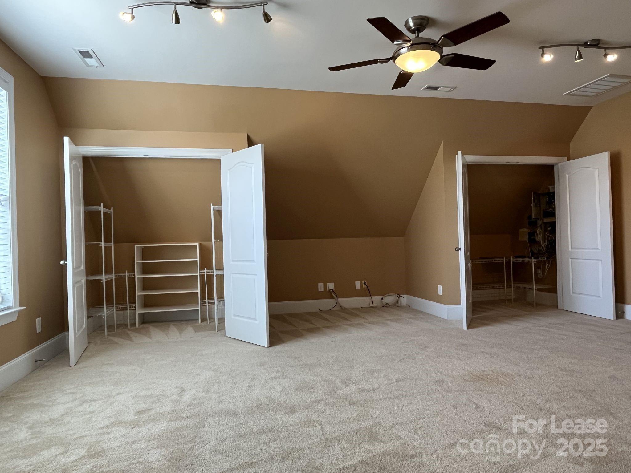 11502 Wheat Ridge Road Charlotte, NC 28277 - Photo 32 of 47 an empty room with closet and a chandelier fan