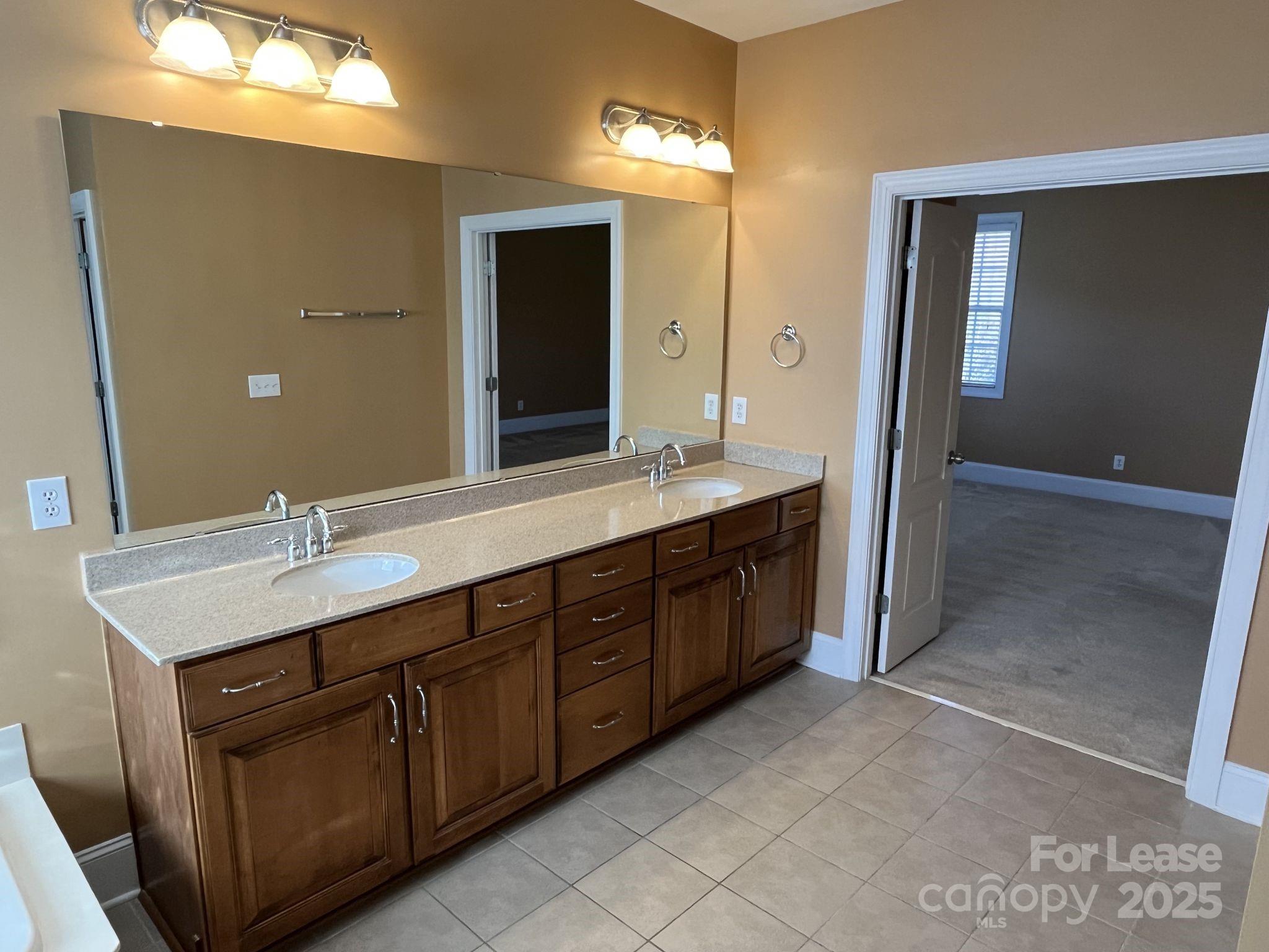 11502 Wheat Ridge Road Charlotte, NC 28277 - Photo 37 of 47 a spacious bathroom with a double vanity sink and a mirror