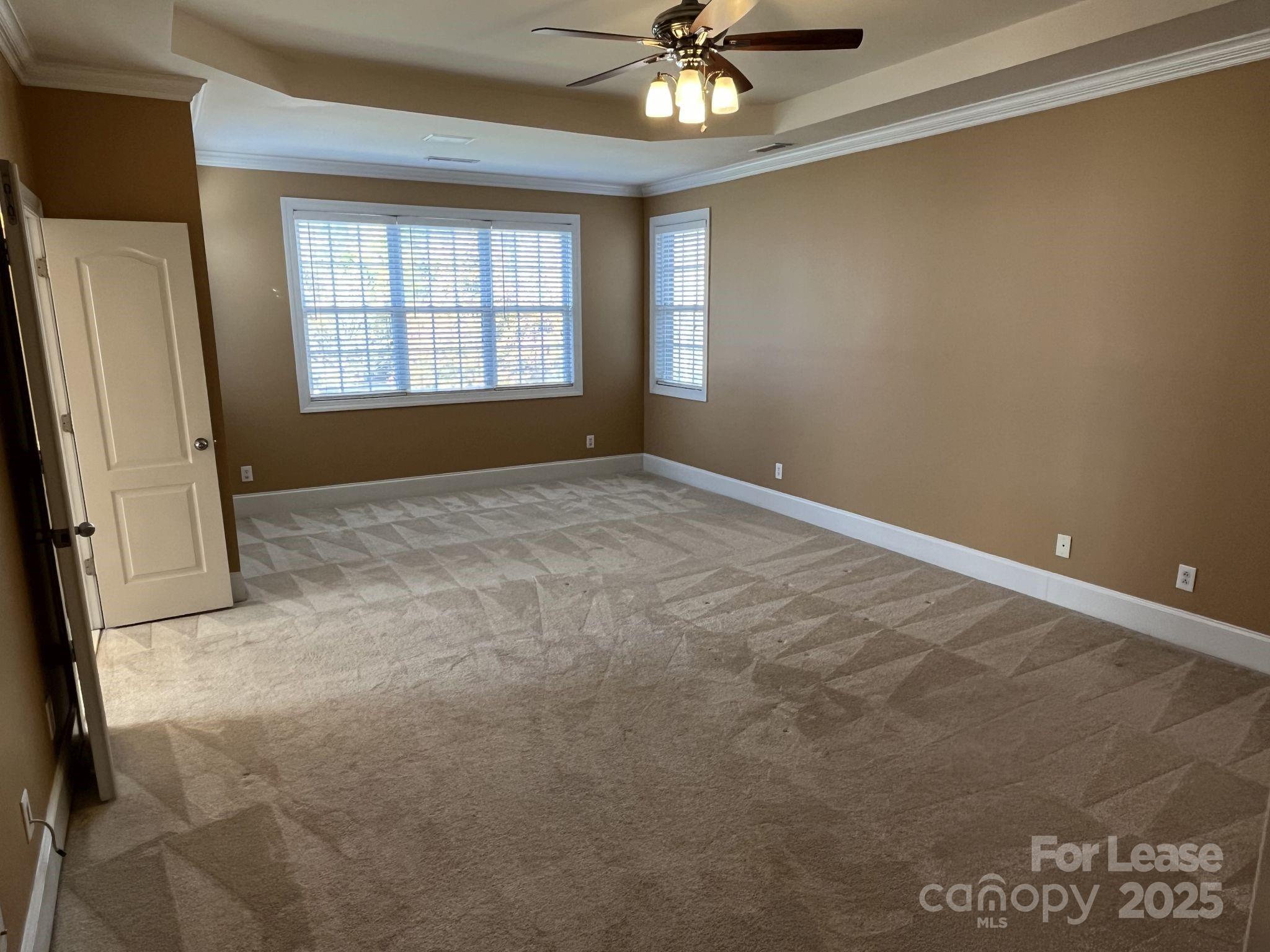 11502 Wheat Ridge Road Charlotte, NC 28277 - Photo 39 of 47 an empty room with chandelier fan and windows