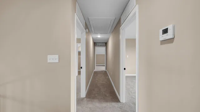 a view of a hallway with wooden floor and a bathroom