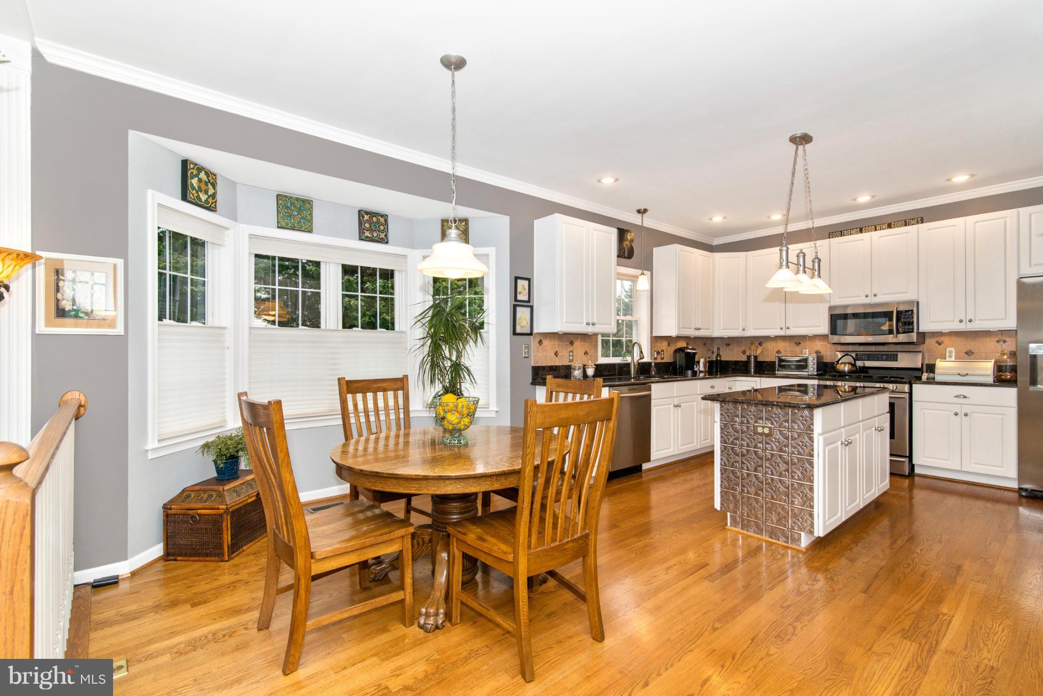 2519 Bear Den Road Frederick, MD 21701 - Photo 19 of 30 a kitchen with stainless steel appliances kitchen island granite countertop a stove a refrigerator a kitchen island a dining table and chairs with wooden floor