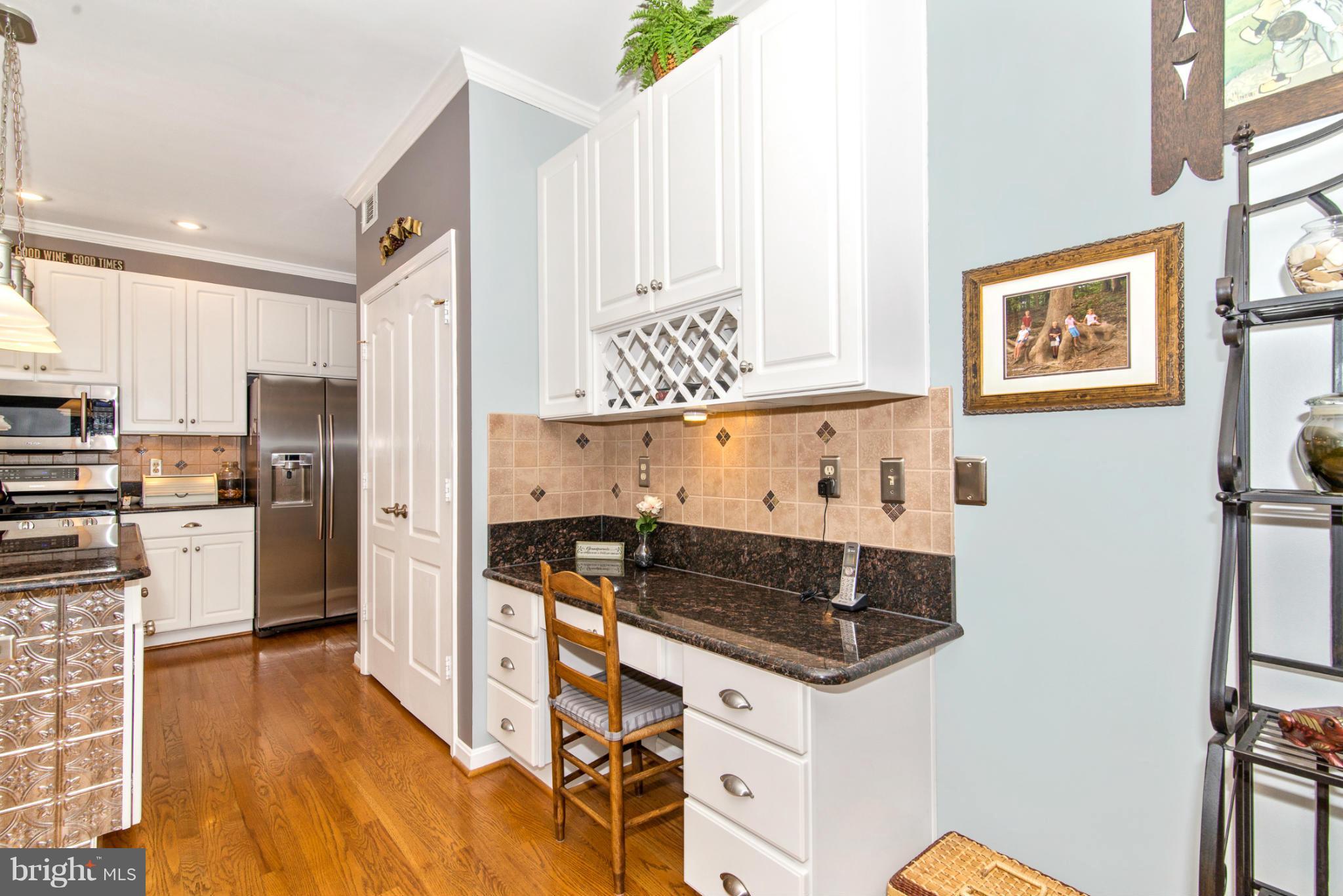 2519 Bear Den Road Frederick, MD 21701 - Photo 20 of 30 a kitchen with granite countertop a refrigerator a stove a sink and white cabinets with wooden floor