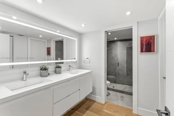 a bathroom with double vanity sinks and a shower