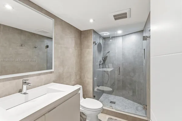 a bathroom with a sink a toilet and shower