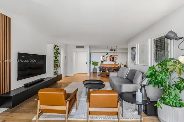a living room with furniture a flat screen tv and a potted plant