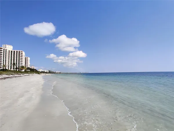 a view of a swimming pool with a lawn chairs under an umbrella