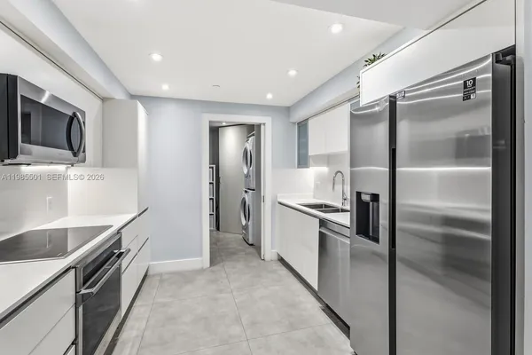 a kitchen with stainless steel appliances granite countertop a refrigerator and a sink