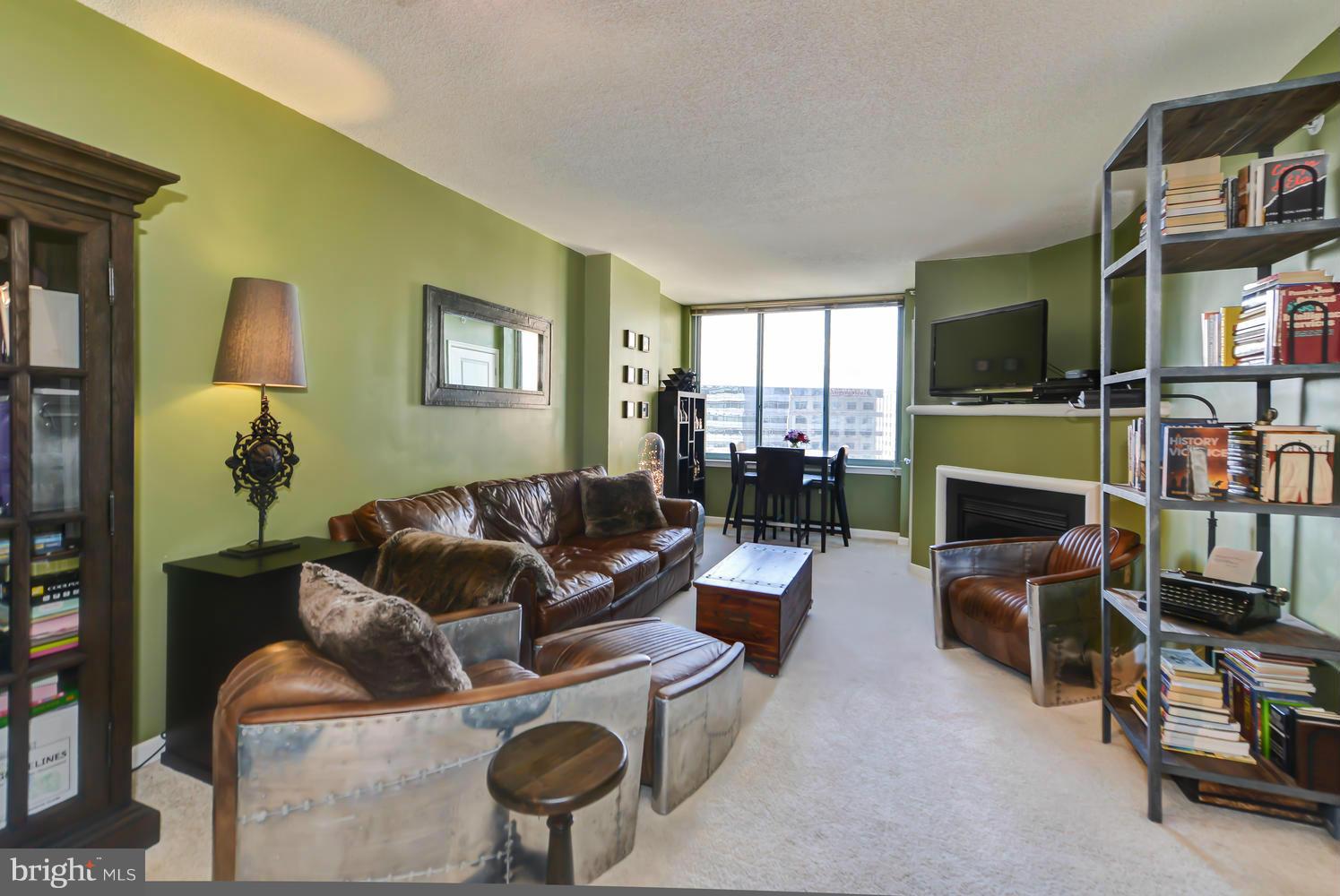 851 North Glebe Road, Unit 902 Arlington, VA 22203 - Photo 3 of 30 a living room with furniture a flat screen tv and a fireplace
