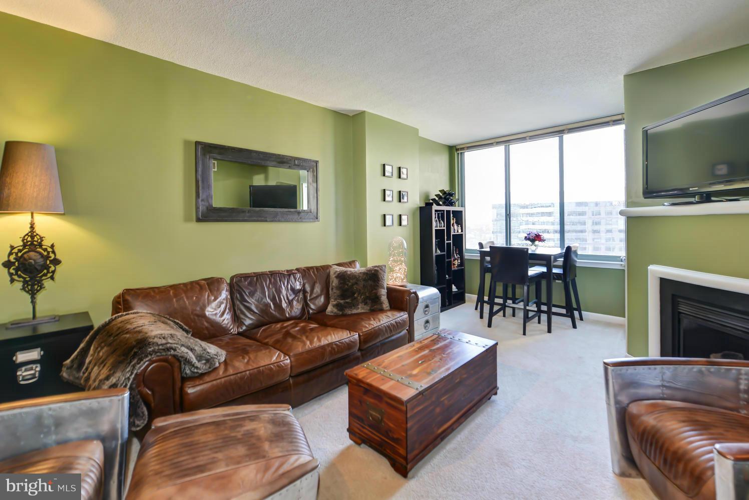 851 North Glebe Road, Unit 902 Arlington, VA 22203 - Photo 4 of 30 a living room with furniture a flat screen tv and a fireplace